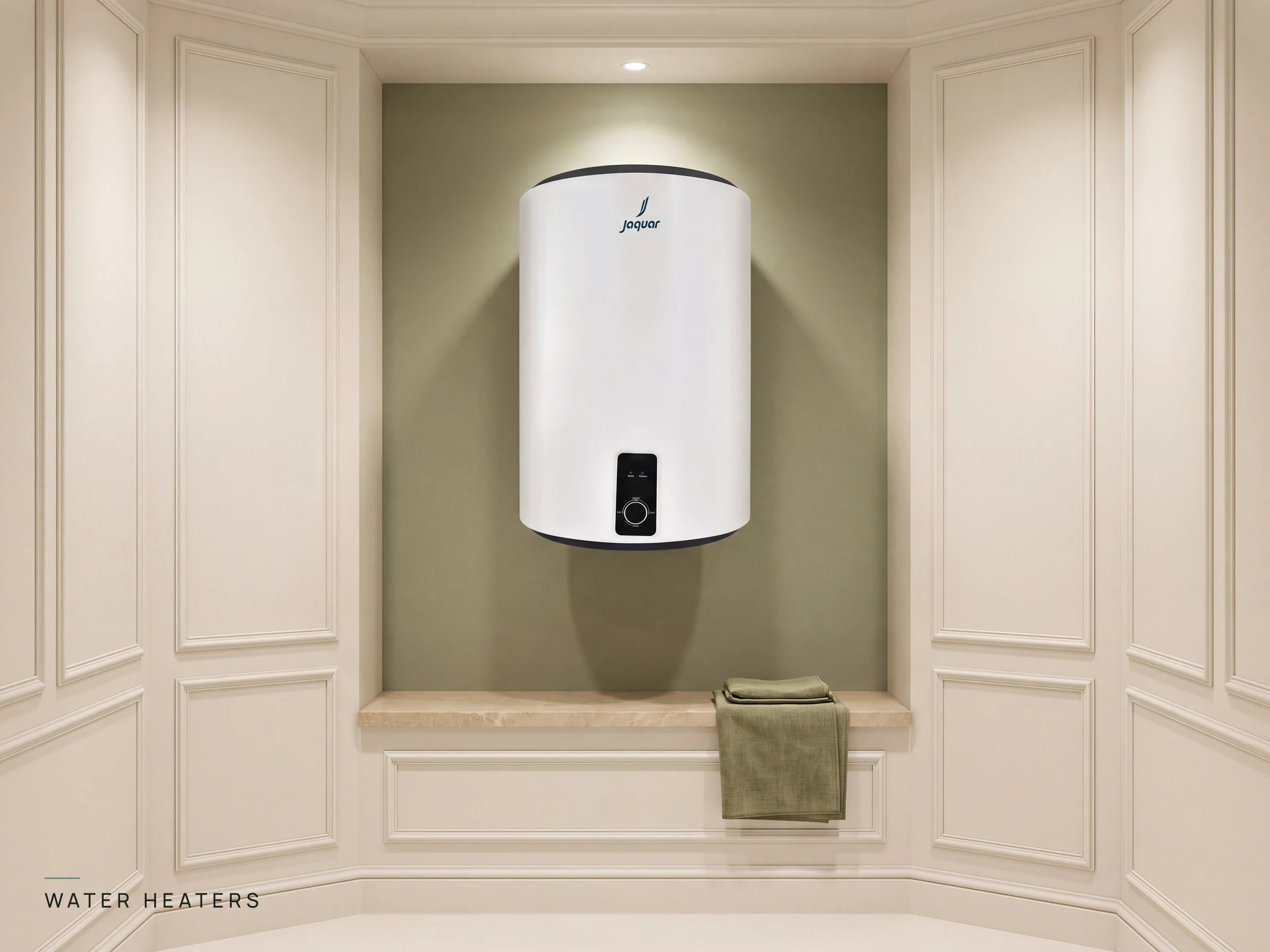 Jaquar vertical storage water heater with digital dial control mounted on a warm sage green showroom wall above a stone ledge with an olive linen towel